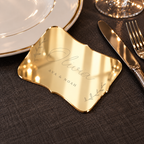 Digital lifestyle visualisation of Olivia mirror gold acrylic place card on a charcoal dining table; styling props not included.