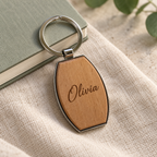 Personalised barrel wood and metal keyring with Olivia example on a neutral lifestyle background; generated visualisation, styling props not included