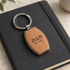 Dad engraving example on the wooden front of a barrel-shaped metal keyring; generated illustration, actual grain and engraving may vary