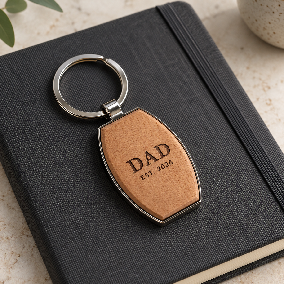 Dad engraving example on the wooden front of a barrel-shaped metal keyring; generated illustration, actual grain and engraving may vary