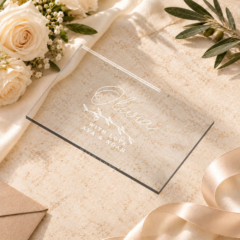 Clear acrylic rectangle wedding place card, Olivia example, in a wedding table setting — digital scene visualization based on fixed artwork; styling props not included.