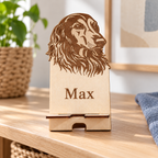 Personalised wooden dog phone stand in a digitally styled setting; name shown is an example, phone and props not included.
