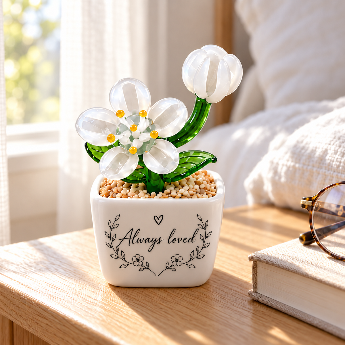 White glass bloom and bud beside a bed with floral Always loved artwork. Personalisation example; one selected pot per order; props not included.