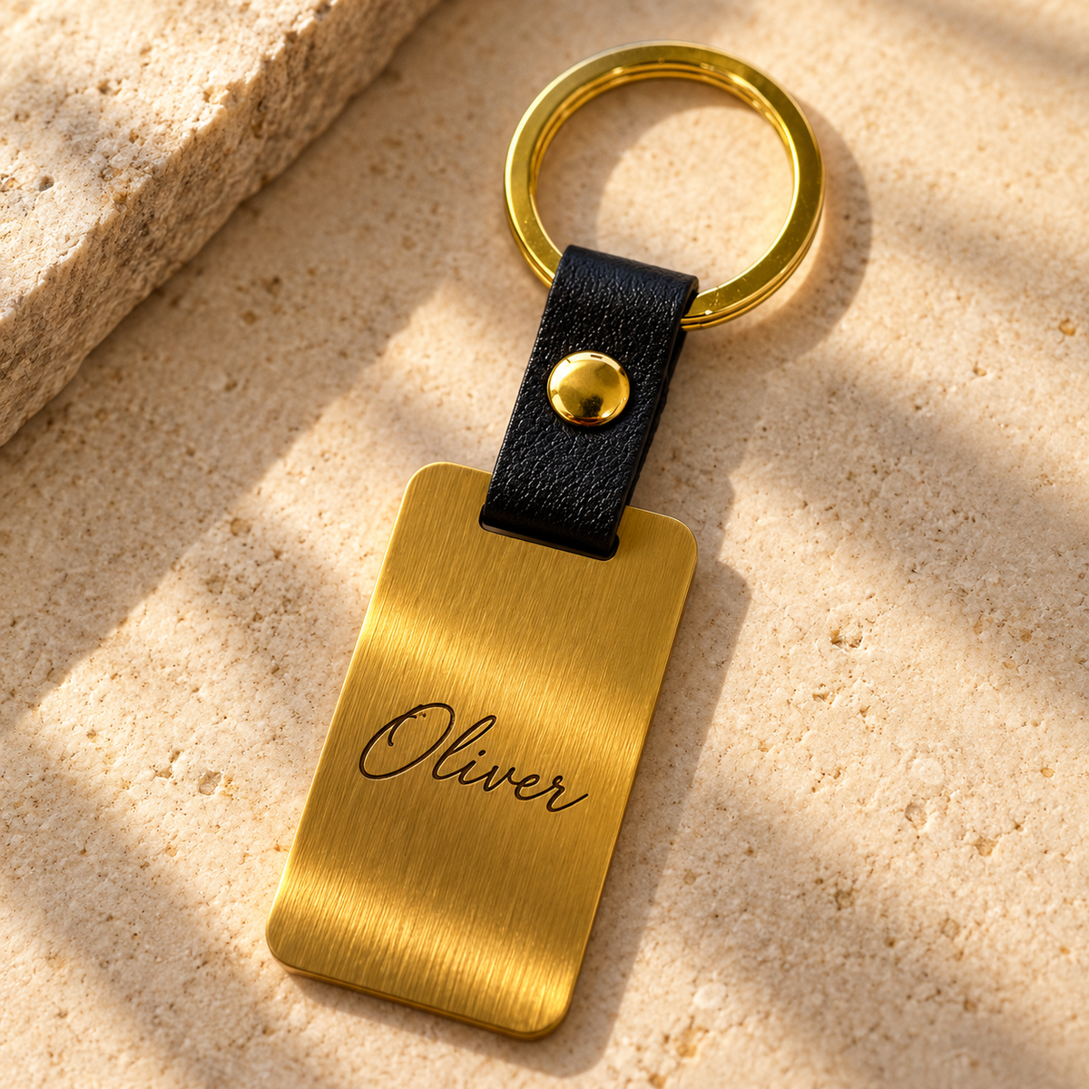 Illustrative gold stainless steel and black leather keyring: 02-name-oliver-engraving