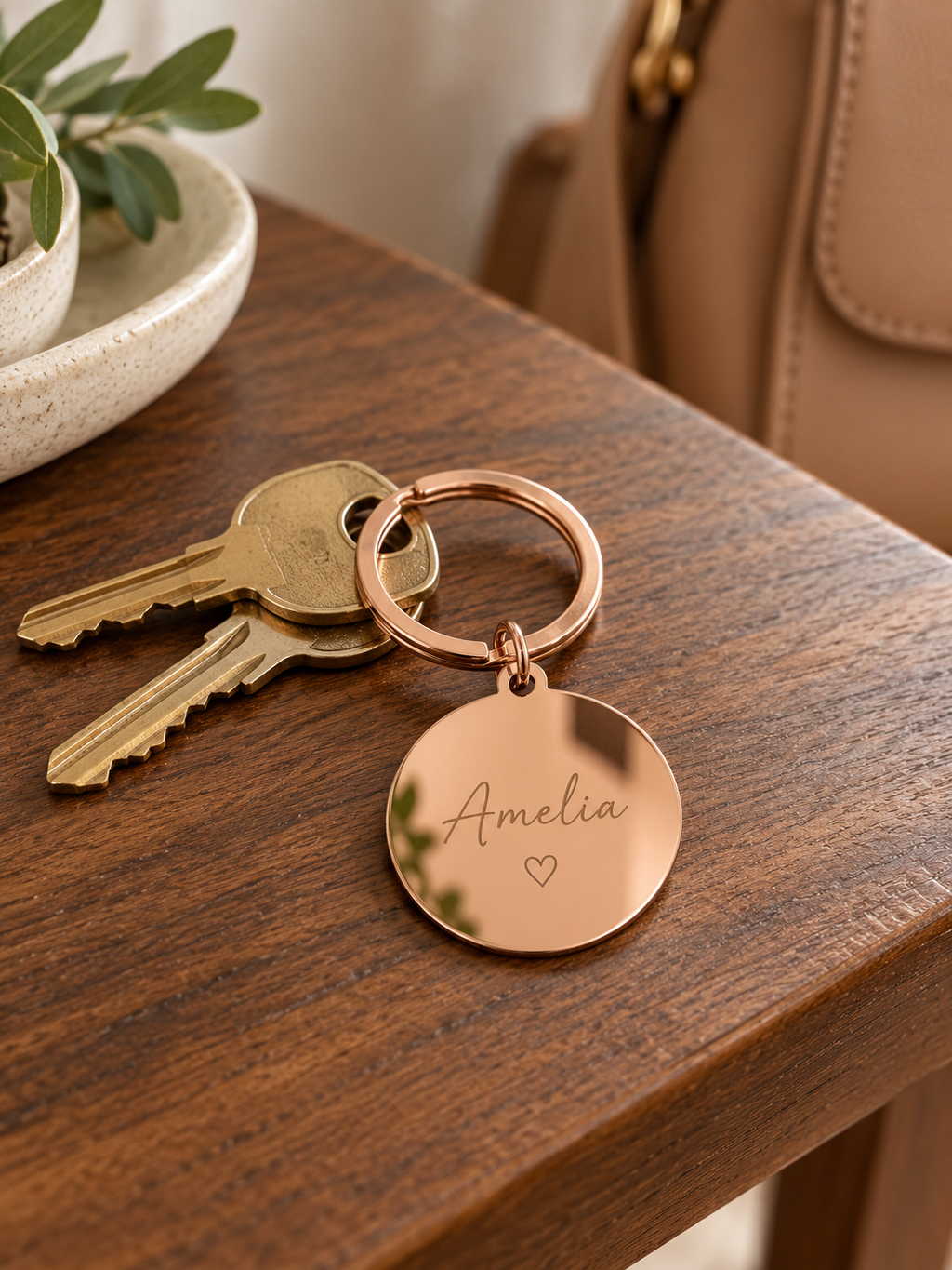 AI lifestyle visualisation of a rose gold keyring with a name engraving example; keys and props not included