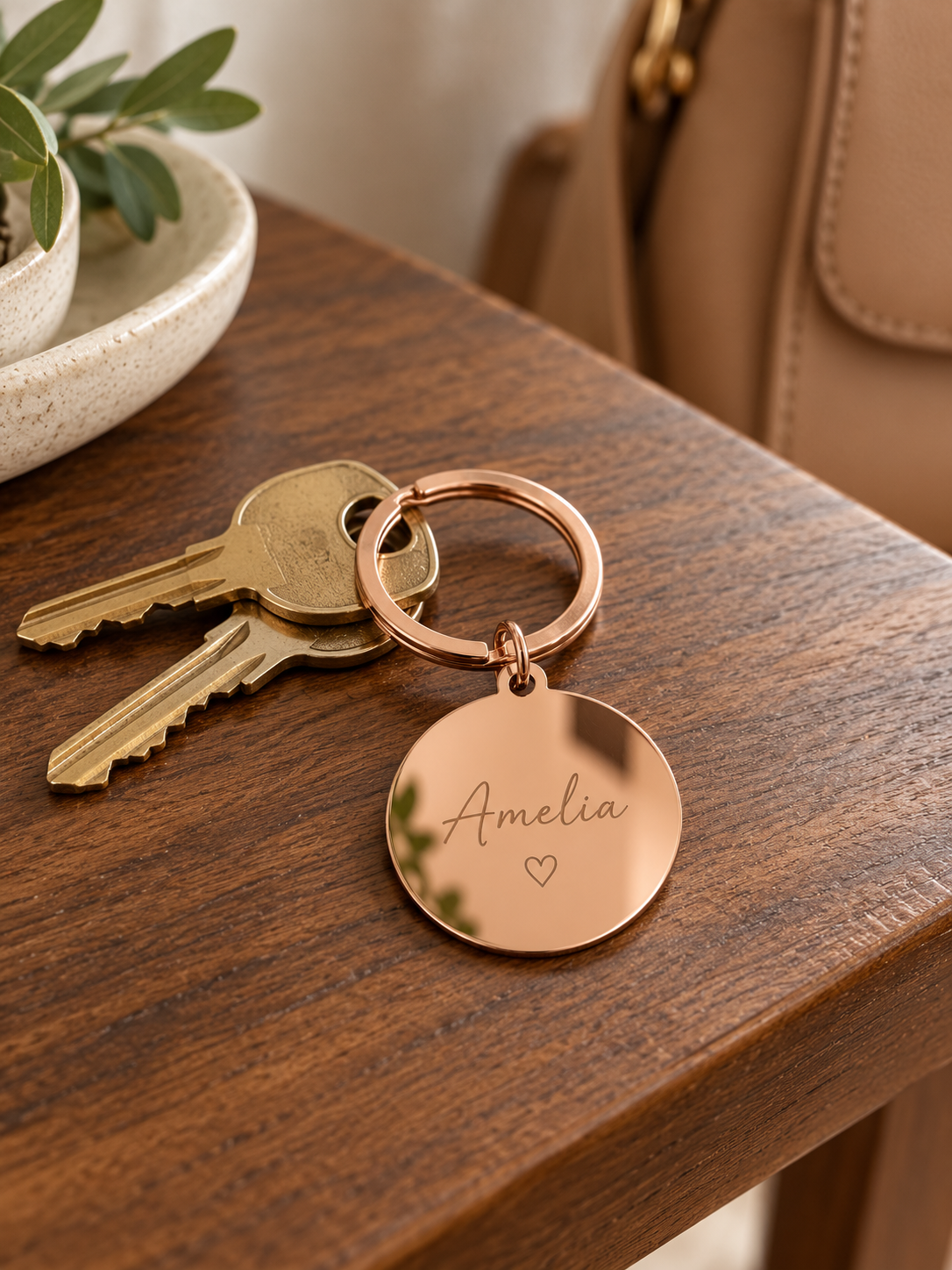 AI lifestyle visualisation of a rose gold keyring with a name engraving example; keys and props not included