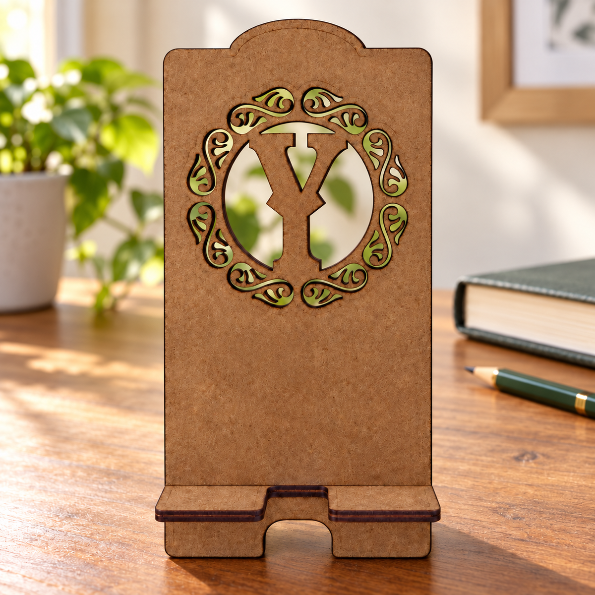 Digital lifestyle visualisation of the dark brown wooden phone stand with a custom initial example; desk props not included.