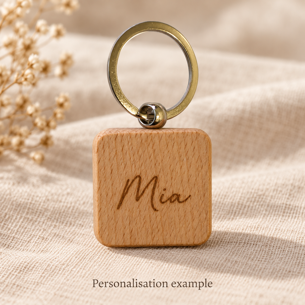 Mia engraving personalisation example on square wooden keyring; generated illustration, not a production sample