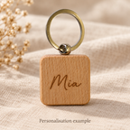 Mia engraving personalisation example on square wooden keyring; generated illustration, not a production sample