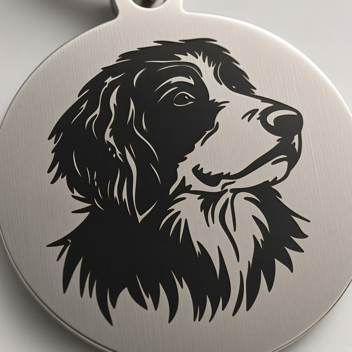 Close-up of the detailed black pet portrait engraving on the brushed stainless steel tag