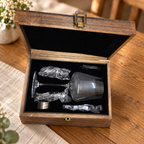 Open wooden wine gift box with one glass and five accessories in black lining